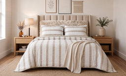 - Product: A 3-piece duvet cover set with double-sided or layered design (visible as a striped quilted comforter and matching pillow shams) laid on a bed.
- Target audience: Unisex or adults; judging from the neutral, beige-toned styling and bedding basics, suitable for men and women.
- Notable attributes: Soft beige and white striped pattern; cozy, textured throw at the foot; matching pillow shams; wooden nightstands and a neutral bedroom setup; warm ambient lighting. Material appears to be a soft, woven fabric with a plush top layer in the headboard area, giving a warm, minimalist bedroom look.