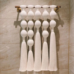 - What the product is: A wall hanging decorative macrame panel featuring multiple knotted tassels arranged in a row, designed to be mounted on a rod.
- Apparent audience: Unisex; styling suits home decor for adults looking to add a boho-chic accent to interiors.
- Notable materials, color, and style: White macrame cords with a natural fiber texture, knotted globe shapes, and long tassels; mounted on a metal rod with end brackets, giving a clean, airy bohemian look.