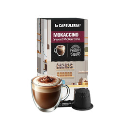 - Description: A box of La Capsuleria Nespresso-compatible mokaccino capsules, shown with one prepared cup of moka-style coffee in a clear double-wall glass mug and a single capsule beside it.
- Audience and styling: Appears unisex, targeted at coffee lovers who use Nespresso-compatible capsules; packaging features a modern, cafe-like backdrop with neutral tones and a pink/maroon label.
- Notable attributes: Sweet Mokaccino flavor, capsule-based coffee, dark chocolate-brown crema in the cup, black capsule with ridged top, compact box packaging with a black, pink, and white label.