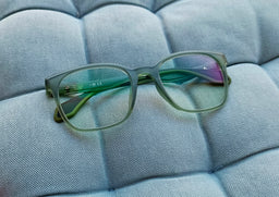 - What the product is: Green-tinted rectangular full-rim glasses with clear lenses, designed as anti blue light glasses.
- Apparent audience: Unisex (sunglasses-like frame on a neutral model, suitable for both men and women based on styling).
- Notable attributes: Transparent green frame with gradient blue-purple lens tint, full-rim acetate/plastic frame, temple arms with subtle hinge detail, lightweight and modern rectangular shape.