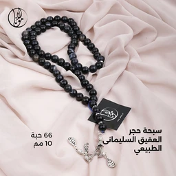 - What the product is: A black natural agate Suleimani (Sultan) prayer bead (rosary) with 66 beads, each bead 10 mm, featuring a silver-toned tassel and decorative metal charms.
- Apparent audience: Unisex (suitable for men and women) judging by the neutral black beads, simple design, and unisex presentation.
- Notable attributes visible: glossy black round beads (10 mm) strung into a 66-bead strand, with a decorative hanging tassel and small metal accents; comes with a small black card tag. The beads appear highly polished and uniformly sized on a soft, light-pink fabric backdrop.