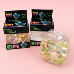 - What it is: Clear Fruit Cube, a translucent cube containing assorted colorful fruit-shaped beads or candies (visible inside the packaging). 
- Intended audience: Unisex (appears as a playful, candy-like classroom/desk charm style item; styling is bright with cartoon packaging).
- Notable attributes: Clear, glossy cubes with multicolor pastel fruit pieces; black display boxes with neon-green text and a blue cartoon character; packaging shows “Nice Cube” and “Super Solid Squish!” suggesting a soft, squishy texture.