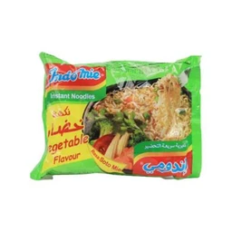 The image shows a bright green package of instant noodles. It appears designed for a vegetable flavor with imagery of noodles and vegetables on the front, suggesting an Instant Noodles product likely intended for a general audience. The packaging features bold multilingual text and a prominent brand logo, with a mix of green, red, and yellow colors and a picture of prepared noodles.