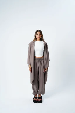 - What it is: A two-piece lounge/set outfit featuring a long open cardigan or duster over a matching wide-leg pants, paired with a white cropped top.
- Audience and styling cues: Appears intended for women, with relaxed-fit, oversized cardigan and drawstring pants giving a casual, comfy loungewear vibe.
- Notable details: Neutral taupe/grey-brown color palette, soft, drapey fabric, cropped white top, and black platform sandals. The look emphasizes a coordinated knit-like set with a cozy, minimal aesthetic.