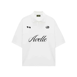 A white polo-style jersey with a classic polo collar and short sleeves. Designed for unisex or general audience based on the relaxed fit and styling, featuring bold black script text “Adelle” across the chest and small logos at the left chest and right chest area. Material appears to be a lightweight knit/fabric typical of polo shirts, with a clean, minimalist aesthetic in white and black.