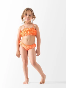 - What the product is: A two-piece swimsuit for a young girl, featuring a ruffled bikini top and matching bottoms.
- Apparent audience: girls (child/youth) judging from the small size, styling, and fit on a child model.
- Notable attributes visible: bright orange color, two-piece set with multiple layers of ruffles on the top and matching ruffled bottoms, thin shoulder straps, lightweight and stretchy fabric.
