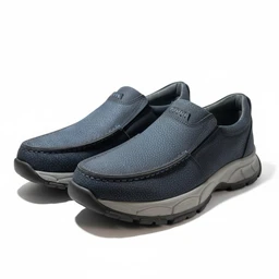A pair of slip-on casual shoes with a blue textured leather-like upper. They appear to be unisex in style, intended for everyday wear, with a padded collar and a thick, two-tone midsole for comfort and support. Notable features include the navy-to-darker blue upper, visible stitching, and a light gray/creamy cushioned outsole.