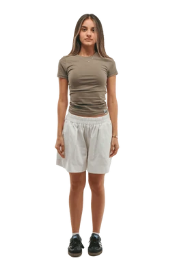 A casual short-sleeve crew top, shown on a female model. The top is fitted, olive/taupe in color, with a round neckline and short puff sleeves. The model pairs it with light gray drawstring shorts and black athletic shoes, suggesting a relaxed, everyday athleisure look. Material appears soft and stretchy for the top; shorts look lightweight with an elastic waistband. Audience: women's. Notable attributes: olive/taupe color, fitted crew neck, short sleeves, slim silhouette; shorts are light gray with an elastic waistband.