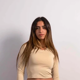 - Product: A cropped, long-sleeve beige top. The fabric looks smooth and form-fitting with a close, rounded neckline.
- Audience and styling: Appears designed for women, shown on a female model with a casual, minimalist styling; intended for a chic, everyday or athleisure look.
- Materials and colors: Solid caramel beige color; lightweight, stretchy knit fabric with a clean, seamless appearance. Notable attributes: cropped length, long sleeves, snug fit.