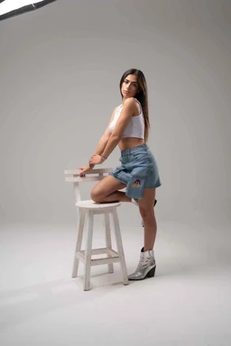 - What the product is: A sleeveless cropped top paired with light-waded distressed denim shorts, shown on a female model in a studio setting. The outfit emphasizes a casual, summery look.
- Apparent audience: Women or girls, judged from the model, cut, and styling (crop top and short shorts).
- Notable attributes: White cropped top, high-rise light blue distressed denim shorts with rolled hems, white ankle boots. The overall style is casual, youthful, and minimal.