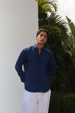 - A dark blue linen shirt worn by a male model. The shirt has a relaxed, slim collar and long sleeves, with a slightly curved hem. The fabric appears lightweight with a matte linen texture.
- Intended audience: men’s. Notable attributes: dark blue color, premium linen material, casual button-down style with a clean, minimal look.