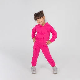 - A bright pink kids’ cargo outfit consisting of a hoodie-style top with a kangaroo pocket and matching jogger pants with multiple cargo pockets. The model is a young girl, suggesting the intended audience is girls.
- Notable materials and styling: soft, stretchy fabric with a hood; multiple utility pockets on the pants and a roomy, casual fit. The look is sporty and casual, finished with silver sneakers.