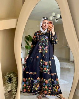 - What it is: A long, loose-fitting maxi dress with a floral print.
- Target audience: Women (modest, full-coverage style; includes a headscarf shown for styling).
- Notable attributes: Dark navy/black base fabric with vibrant multicolor floral embroidery along the chest, sleeves, and hem; long sleeves; ankle-length; round neckline; tiered skirt with floral borders. No visible brand logos.