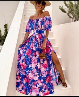 - What it is: A women's off-shoulder floral maxi dress with a full skirt and side slit, modeled with a straw hat and sandals.
- Intended audience: Women.
- Notable attributes: Bright blue base with large pink and white floral print, off-the-shoulder neckline, cinched waist, flowing ankle-length skirt, side slit, lightweight breathable fabric. No brand visible.