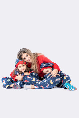 A matching women's pajama set featuring a red long-sleeve top and coordinating plaid/printed pants with a festive, multicolor pattern. The styling shows a mother and two kids wearing the coordinated outfits, suggesting a family or lounge-wear set aimed at women (and possibly children). Notable attributes visible: red solid top, blue patterned pants with prints, cozy knit/fleece look, relaxed fit, full-length pants and long sleeves.