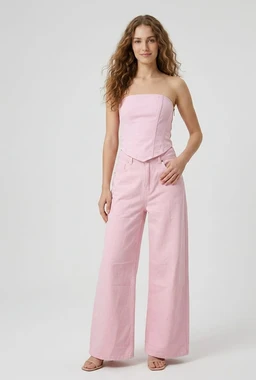 - What it is: A light pink denim jumpsuit with a strapless, fitted bodice and wide-leg pants.
- Audience indicators: Designed for women; model styling is feminine with a strapless neckline and relaxed, wide-leg silhouette.
- Notable attributes: Soft pink denim fabric; strapless square neckline; high-waisted fit; wide-leg cut; clean, minimal seams; neutral sandals to complete look.