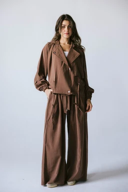 - Description: A matching brown two-piece set consisting of a loose, oversized jacket with a wide lapel and a matching wide-leg trouser/s wide-legged pants, worn by a female model.
- Audience and styling cues: Appears styled for women, with relaxed, casual-sity vibes and a contemporary, feminine silhouette suitable for everyday wear or lounge-set styling.
- Notable attributes: Brown earthy tone; lightweight, soft fabric with a structured yet drapey drape; set includes a belted or tie waist detail and voluminous sleeves; full-length pants with a wide leg.