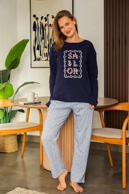 - Product: Navy blue long-sleeve pajama top paired with light blue patterned pajama pants.
- Audience: Women's (based on the model and styling).
- Notable attributes: Top features a graphic print with a layered word design; pants are loose-fitting with a light, soft fabric pattern. Overall look is a comfortable, casual loungewear set in navy and pale blue hues. No brand markings visible.