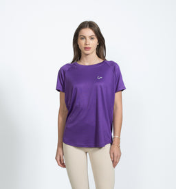 A purple short-sleeve T-shirt with a relaxed, slightly loose fit. The model appears to be a female, styling with light beige pants; the shirt has a small subtle logo on the left chest. Material looks soft and smooth, likely cotton or a cotton-blend, with a solid vibrant purple color and a classic crew neck.