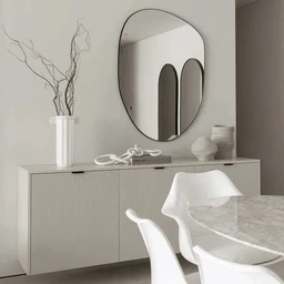 - A wooden MDF cabinet with a light, neutral finish sits against a pale wall beneath a large, oval wall mirror. The cabinet has a ribbed panel front and clean, contemporary lines, with dark slim handles. The room features minimal decor: a tall white vase with branch stems, a decorative white rope, and soft white ceramics, contributing to a calm, modern dining/loyer area vibe.
- Intended audience: unisex (general home furniture).
- Notable attributes visible: material appears to be MDF wood with a light beige/gray finish; dimensions roughly 120 cm L x 35 cm D x 80 cm H as stated; style is modern minimalist with a subtle vertical groove texture and simple hardware. Color palette is light neutral tones (off-white/cream).