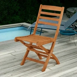This is an outdoor folding chair made of natural wood (likely beach or patio grade). It features a slatted back and seat with a light honey-brown finish, angled legs, and a simple, rustic style suitable for lounging by a pool or garden. The visible audience appears to be unisex adults; material highlights include solid wood with a smooth varnished surface.