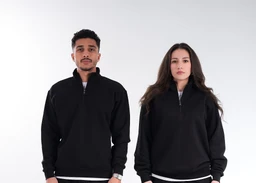 - A black quarter-zip pullover with a short stand collar and zip closure, shown on a male and female model in a clean studio setting. 
- Intended audience appears unisex, based on the two-fit presentation; features a relaxed, slightly tapered silhouette with ribbed cuffs and hem. 
- Notable details include solid black color, lightweight fleece-like material, and a minimalist, classic sporty style with visible quarter-zip and subtle design lines at the collar.