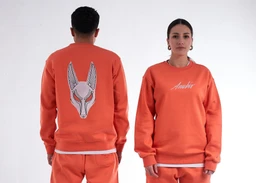 - What it is: A bright orange crewneck sweatshirt set (shown from front and back) with matching jogger pants. The back features a large graphic of an Anubis-inspired fox/ jackal head; the front shows a script-style text graphic.
- Audience and styling cues: Designed for a unisex or casual streetwear audience, with relaxed fit, ribbed cuffs and hem, and a white accent layer peeking from the waistband and hem for contrast.
- Materials, color, and notable attributes: Dominant neon orange color; soft fleece-like fabric; white printed graphics on the back and front; relaxed crewneck silhouette with long sleeves. No brand logos visible.