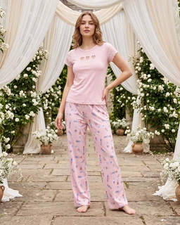- What the product is: A women’s pajama set consisting of a short-sleeve top and full-length pants, styled for comfort and sleepwear.
- Apparent audience: Women (unmistakable feminine fit, pastel pink color, and floral print accents).
- Notable attributes visible: Soft pink fabric, short-sleeved crew neck top with small cutout/flower details across the chest, matching light pink pajama pants with a small floral/graphic print. The overall look is cozy, with a relaxed, loose fit and a pastel, romantic style.