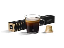 This is a Nespresso coffee capsule set featuring Caramello-flavored capsules. It appears unisex, presented with a standard coffee cup and a single beige Nespresso capsule alongside the closed packaging; the visible style is minimalist black packaging with a small gold accent. The notable attributes are the dark espresso color of the brew, the caramel-toned crema, and the beige capsule color designed for Nespresso machines.