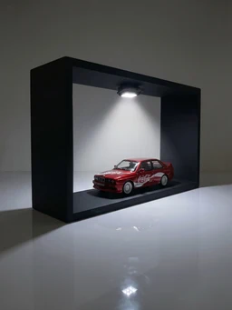 - What the product is: A scale model car displayed inside a small black display box with a white backdrop and a focused ceiling light.
- Apparent audience: Unisex (model appears suitable for all ages interested in collectible car replicas).
- Notable attributes: Red Coca-Cola livery on a BMW M3 E30 miniature, white decals, detailed small wheels; minimalistic black display case with spotlight highlighting the model.