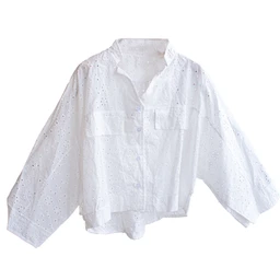 This is a white, oversized button-front shirt with a lightweight, eyelet-embroidered fabric. It features a collared neckline, two chest pockets, and voluminous long sleeves, giving a relaxed, airy look. The material appears to be breathable cotton eyelet in white, with delicate cut-out patterns and a casual, summery style suitable for women or unisex.
