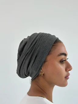 This appears to be a soft, layered head wrap or turban-style beanie in a stone gray color. Likely intended for women, shown wrapped around the head with a draped, voluminous fold for a casual, cozy look. Material appears to be a knit fabric with a smooth, medium-weight knit texture and a neutral gray shade.