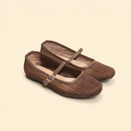 These are brown ballet flats with a pleated, textured fabric upper and a rounded toe. They feature a thin Mary Jane strap with a small buckle, and a low-profile sole suitable for everyday wear. Likely intended for women, the design emphasizes a soft, earthy brown color and subtle, feminine styling.