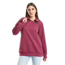 - Product: A women’s hoodie with a high neck in a wine/purple color. The garment features a quilted textured knit across the front and sleeves, with a relaxed, slightly oversized fit. It has a polo-style collar that raises up, long sleeves, ribbed cuffs, and a ribbed hem. The model pairs it with light denim jeans for a casual, everyday look. 
- Intended audience: Women.
- Notable attributes visible: quilted knit texture, high collar, long sleeves, relaxed/oversized silhouette, solid plum-purple color, casual pullover hoodie style.