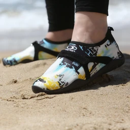 Product: Casual water-sport/athletic shoes with a sand-ready strap design.
Audience: Unisex (suitable for men or women), judging from the low-cut, sporty fit and adjustable straps.
Notable attributes: Multi-color graphic upper with white, blue, yellow accents; black Velcro strap closures; black sole/trim; low-profile, beach-friendly outsole. Material appears to be a flexible synthetic upper with reinforced strap and gripping outsole.