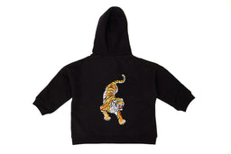 This is a kids' hooded zip-up sweatshirt in black, featuring a tiger graphic on the front. The styling and sizing indicate it’s intended for children, with a roomy fit and a mid-weight knit suitable for casual wear. Notable details include the bright tiger applique/print in orange, yellow, and white, plus a front zipper and a hood.
