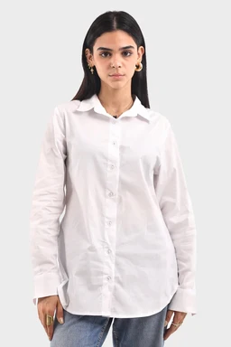 White button-down shirt with a rounded trim detail along the collar. The shirt is worn by a female model, suggesting a women's sizing, with a relaxed, slightly oversized fit. Visible materials appear to be lightweight cotton or cotton-blend in solid white; features include long sleeves, a classic collar, and front button placket. The styling is casual yet polished, paired with jeans and simple gold hoop earrings.