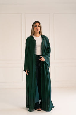 - A long, open-front cardigan or wrap in a deep emerald green, draping loosely to the floor.
- Appears modeled by a woman in a light top and dark jeans, suggesting a unisex-to-feminine casual chic style; the overall look reads as feminine due to silhouette and fit.
- Notable attributes: sheer, flowy fabric, full-length sleeves, solid rich green color, soft drape with a relaxed, voluminous cut.