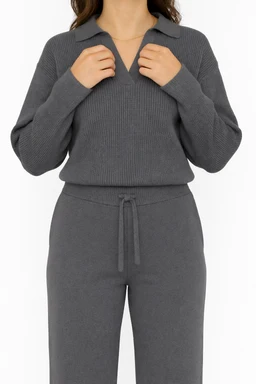 - What the product is: A matching knitted top and jogger set in a soft, heather gray tone, shown as a two-piece lounge/athleisure outfit.
- Apparent audience: Women, based on the fitted yet relaxed silhouette, v-neck polo-style neckline, and tie-front/elastic waistband.
- Notable attributes: Knit fabric with ribbed texture, long sleeves, relaxed polo-style top with a partial V-neck collar, matching high-waisted jogger pants with a drawstring, tapered leg, and clean finish. Colors: solid gray. Style: casual, comfortable loungewear.