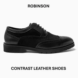 A black leather oxford-style shoe with brogue detailing along the toe and panels, featuring a classic lace-up closure. The design appears aimed at men, with a formal, polished look and subtle contrast stitching. Notable attributes include smooth and textured leather panels, brogue perforations, a rounded toe, and a sturdy rubber sole.