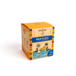 - A small, square box of Nile Blend specialty coffee bags. The packaging features bright orange top panels with colorful geometric side borders and a tropical scene illustration on the front, including palm trees and a boat by the water.
- Audience: unisex (suitable for all adults based on neutral tropical design).
- Notable attributes visible: vibrant orange and blue color scheme, tropical illustration, brand name “REØAF” on the label, and “NILE BLEND” prominently displayed along a blue band. The box appears to be a single-serve or small-batch coffee bag product.