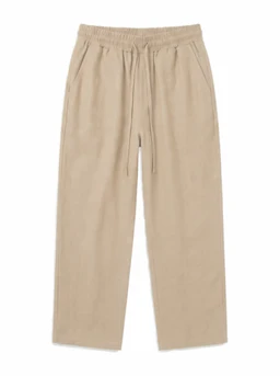 These are wide-cut, beige linen-style pants with an elastic waistband and a drawstring for adjustable wear. They appear to be designed for a relaxed, casual fit suitable for men or unisex use, based on the cut and styling. Visible features include the soft, breathable fabric, a loose straight leg, and a simple, minimal aesthetic in a light, natural beige color.