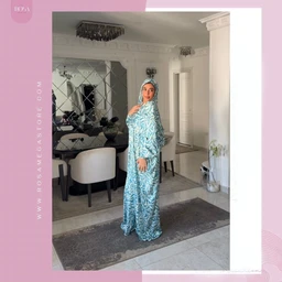 - What the product is: A long, flowing ablution-ready dress (abaya) with a matching headscarf.
- Apparent audience: Women (modest, full-body coverage style with hijab).
- Notable attributes: Light blue and white abstract/leaf-like print, full-length robe with long sleeves, matching hijab, and a loose, elegant cut. The fabric appears lightweight with a soft drape.