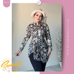 - What the product is: A long-sleeve, lace-patterned tunic or swim-cover busting style top with a high-low hem, worn over dark leggings.
- Apparent intended audience: Women; the styling and model’s fit suggest adult female sizing.
- Notable attributes: Black and white floral lace pattern, sheer long sleeves, mandarin-style collar with button placket, fitted waist creating a peplum-like flare, lightweight fabric. The photo shows a sun hat as an accessory, but information is limited to visible apparel.