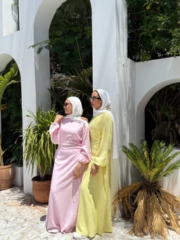 - What it is: A long-sleeve, full-length maxi dress with a relaxed, modest silhouette. The model styling suggests a feminine, contemporary modest wear look.
- Apparent audience: Women. The cut, hijab-friendly styling, and full-length coverage target adult female shoppers.
- Notable materials, color, style: Soft pastel colors—one in pale pink and the other in light yellow. Lightweight, breathable fabric with a flowing, unstructured drape and simple, elegant lines. The outfits feature long sleeves and floor-length hems suitable for modest fashion.