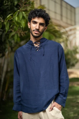 A navy oversized long-sleeve shirt made of lightweight linen, shown on a male model. The fit is loose and relaxed with a slightly drop-shoulder silhouette, long sleeves, and a gathered drawstring neckline. Visible attributes include the navy color, textured linen fabric, and a casual, streetwear-inspired style.