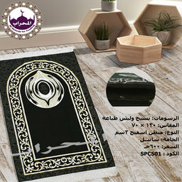 - Description: A black prayer rug with an ornate beige border and central emblem, laid on a light wooden floor with decorative hexagonal wooden shelves in the background.
- Audience and style cues: Appears unisex and suitable for general use; design is traditional Islamic with a floral/arabesque border and a stylized motif at the top.
- Visible materials and colors: Black rug with cream/beige pattern; likely textile material; surrounding decor is light wood and neutral tones. No brand visible.