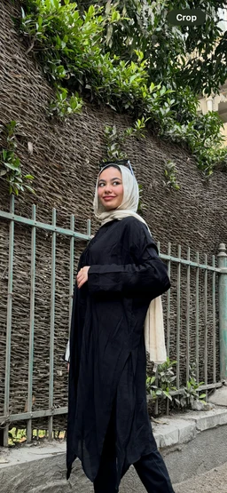 - What the product is: A black asymmetry cardigan with a loose, long silhouette.
- Apparent audience: Women (model wearing a hijab and modest styling suggests feminine presentation).
- Notable attributes: Black shade, oversized drape, asymmetric hem, long sleeves, layered modest styling. Material appears lightweight knit or jersey with a smooth finish. The cardigan is paired with a light-colored hijab and simple accessories for a modest, contemporary look.