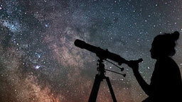 - What it is: A person using a telescope mounted on a tripod, aiming at a starry night sky.
- Apparent audience: Unisex, judged from the silhouette and equipment; could be for stargazing enthusiasts of any gender.
- Notable attributes: Dark sky scene with stars; a long telescope on a tripod; the person is silhouetted, possibly a woman or girl given hair tied up, but no definitive gender; no visible brand or text. Material and color: black telescope/tripod silhouette against a blue-black night sky with stars; emphasis on astronomy and outdoor gear style.