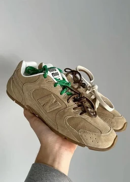 - Product: A pair of casual sneakers with suede panels in brown tones.
- Intended audience: Unisex (appears suitable for both men and women based on design and sizing cues).
- Notable details: Suede upper in brown, with multi-tone lace colors (green and brown/cream), chunky sole, and visible stitching. The shoe features a sporty, retro-running style with side panel stitching and a logo patch hint. No brand names are identified beyond the visible design elements.